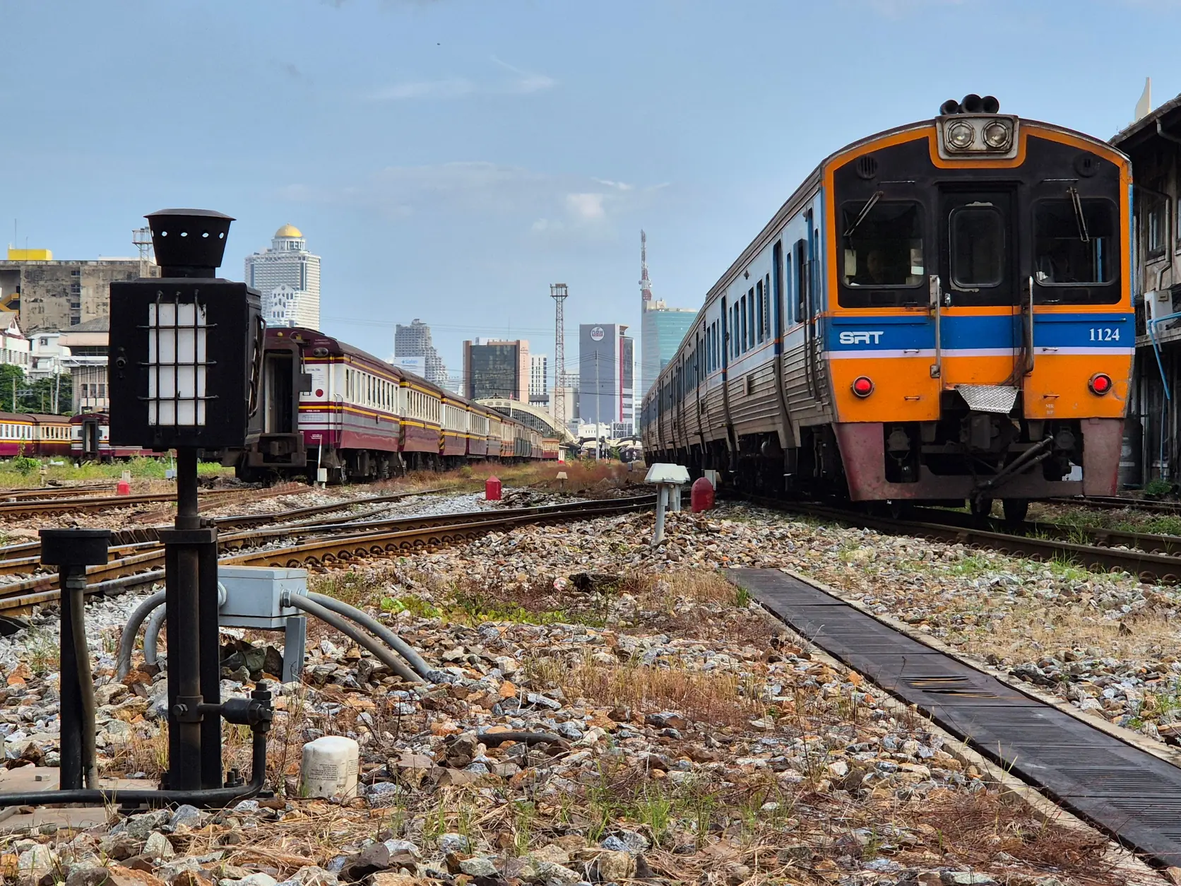 Ein Zug der thailändischen Staatsbahn vor Bangkoks Skyline