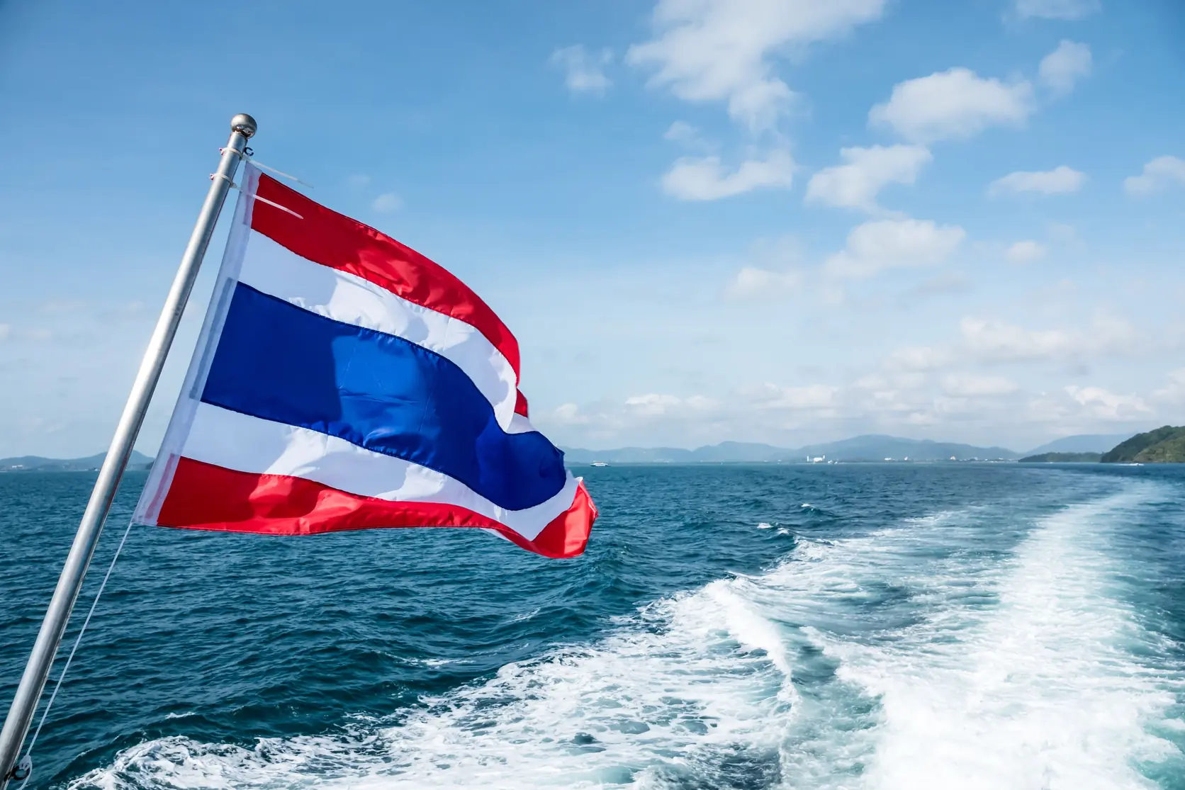La bandera tailandesa en la popa de un barco en el mar