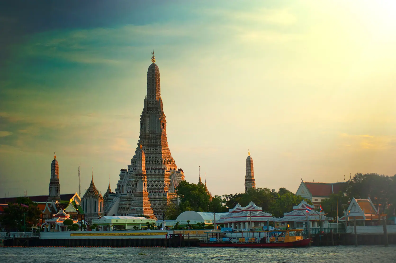 Wat Arun beside the Chao Phraya River in Bangkok at sunset